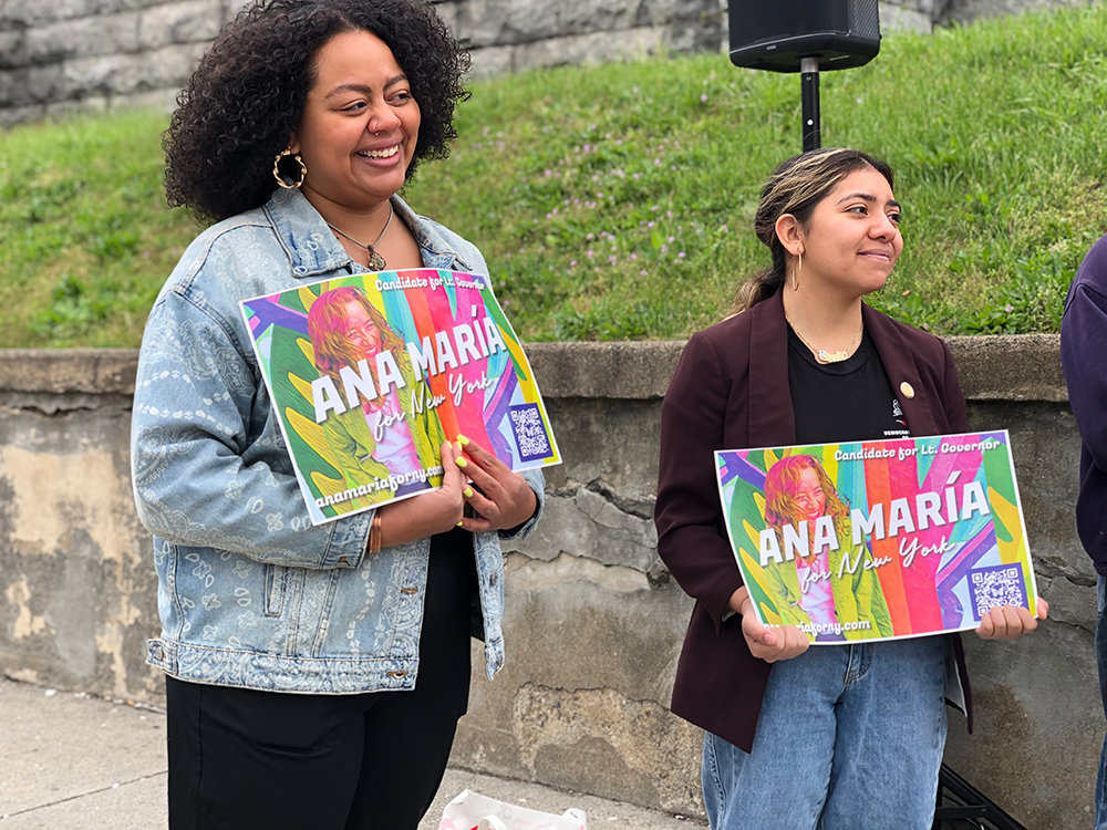 Orange County Legislator Genesis Ramos and Newburgh City Councilwoman Giselle Martinez hold signs in support of Ana María Archila.